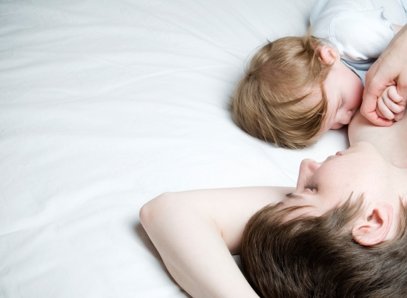 Mutter stillt ein Baby im Bett
