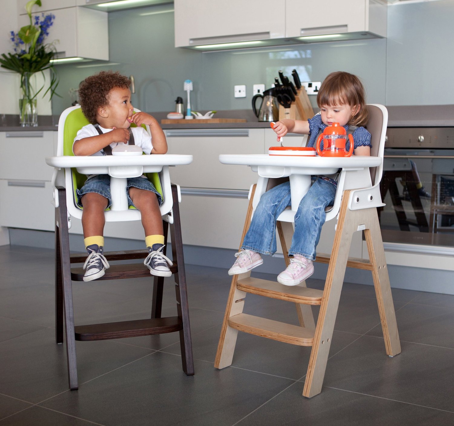 Zwei Kinder sitzen in zwei Hochstühlen